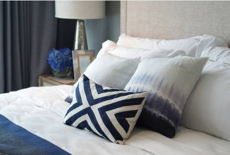 Primary bedroom with layered bedding and bedside styling